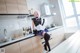 A woman in a maid outfit standing in a kitchen.