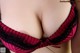 A close up of a woman wearing a red and black bra.