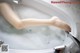 A woman's feet in a bathtub filled with foam.