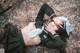 A woman laying on the ground with a sword in her hand.