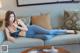 A woman laying on a blue couch in a living room.