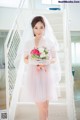 A woman in a wedding dress holding a bouquet of flowers.